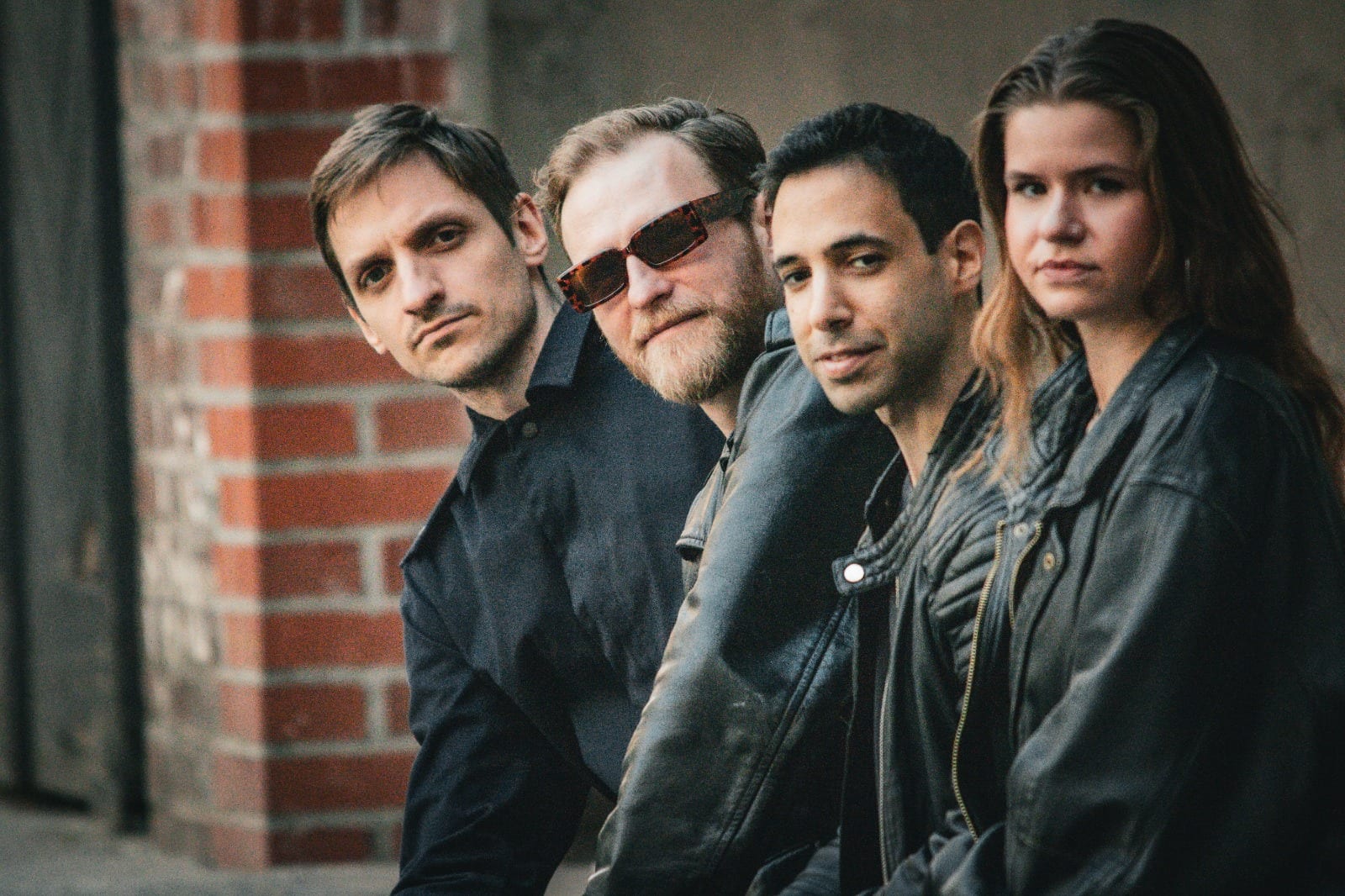 Desert Lake — die vier Bandmitglieder vor einer Backsteinwand, alle blicken in die Kamera