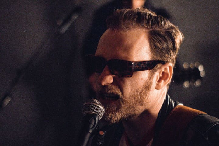 Sänger mit Sonnenbrille am Mikrofon, Nahaufnahme